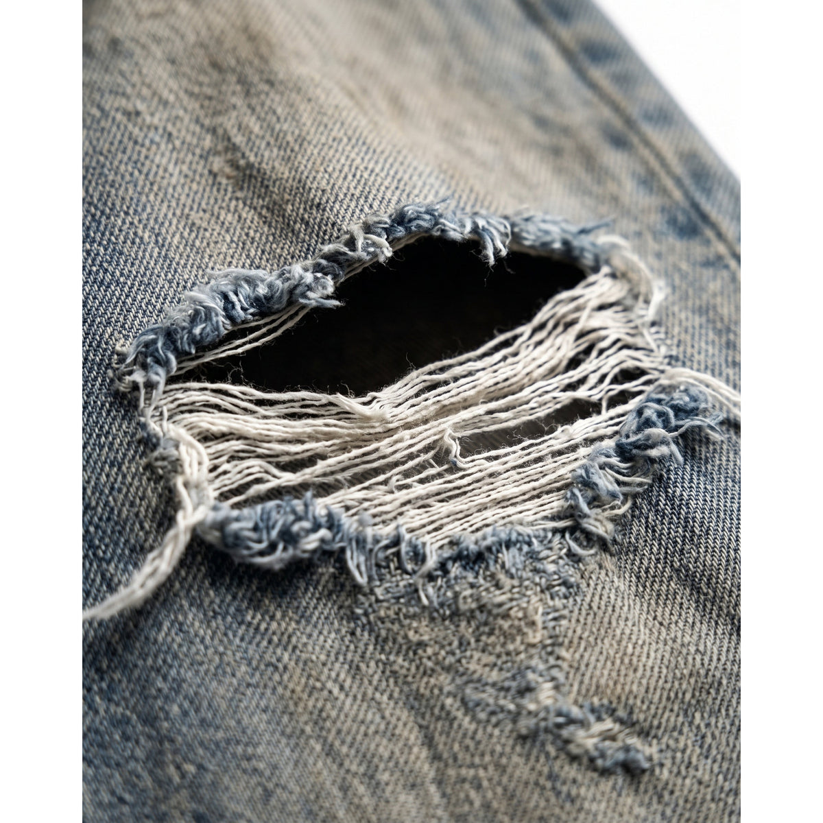 Detail des ausgefransten Risses am Knie